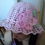 Cappello in cotone rosa con fiore e foglie verdi