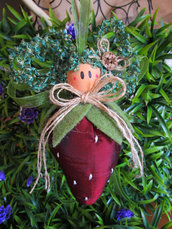 Bambolina a forma di fragola in stoffa di raso colorata con fiocchi e testina in legno