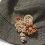 Spilla decorativa per cappello,borsa,giacca.Fiori di lana a telaio,foglie e riccioli all'uncinetto.Aggiunta di perline