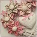 Cuore/fiocco nascita in vimini con 5 fiori in cotone sui toni del rosa e beige ,farfalla e cuore centrale
