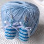 Orecchini pendenti con uova di Pasqua amigurumi a righe azzurre e blu e fiocchetti di raso, fatti a mano all'uncinetto