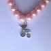 Braccialetto elastico con perle rosa confetto e ciondolini a tema bebè, per future mamme