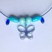 Collana girocollo blu e azzurra con ciondolo a farfalla e perle in legno, fatta a mano 