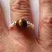 Anello elastico con pietra simil occhio di tigre e perline bianche