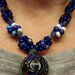 Collana con ciondolo etnico e gruppi di perline a nodi  sul blu