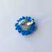 Anello regolabile con fiore azzurro e blu e strass, fatto a mano all'uncinetto 