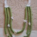 Bracciale in maglia di lana verde prato,tubolare.Inserite 3 margherite in cotone bianco(uncinetto)e perline gialle.Parte di una parure