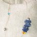 Collana di corda con quadrati di plastica e perle blu