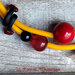 Collana semirigida gialla con perle rosse e nere