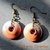 Orecchini pendenti in bronzo con bottoni arancioni