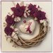 Corona in salice naturale decorata con rose di lino color ciclamino e cuore con cervo