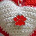 Cuori Amigurumi all’uncinetto, in 100% cotone di colore rosso e bianco, con imbottitura in poliestere, e charms rosso a forma di orma di zampetta;