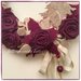 Corona in salice decorata con rose di lino color ciclamino e alberelli