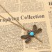 collana color bronzo con ciondolo a forma di libellula decorato con cabochon azzurro e strass