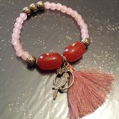 Bracciale elastico perline rosa, nappina rosa cipria e ciondolo uccellino