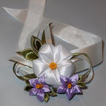Corsage kanzashi con fiori bianchi e lilla.