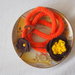 BRACCIALE arancione zucca in lana tubolare.Tre fili.Applicazione di fiori in feltro marrone e giallo.Bottone a cuore in legno,perla.Accessorio,gioiello invernale.