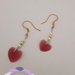 Orecchini pendenti con cuore rosso in acrilico e perline.