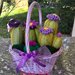 Composizione di cactus in feltro con fiori lilla e viola, in cestino di vimini lilla con manico