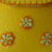 Piccolo portafoglio da bambina realizzato in feltro cucito a mano e decorato con fiorellini di cotone