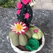 Composizione di cactus di feltro in cestino di vimini rotondo, con fiori di feltro rosa e fucsia