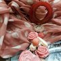 foulard toni rosa antico e pois bianchi, modello con ciondolo sotto il collo 