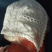 cuffietta da neonato in lana/seta bianca con trecce e trafori