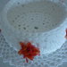 Cestino bianco realizzato a uncinetto con contorno di fiorellini arancio