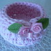 Cestino tondo di colore rosa realizzato a uncinetto con fettuccia e roselline 