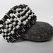 Bracciale elastico nero e bianco con spille da balia e perline colorate