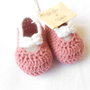 Scarpine crochet ballerine in lana rosa, con fiocco bianco.