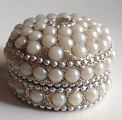 Bombiera di perle bianche illuminate da un sottofondo d'argento
