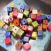 20 perle cubiche forate multicolori in resina