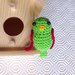 Casetta di legno con pappagallino amigurumi verde e rosso fatto a mano all'uncinetto