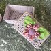 Cestino rigido all'uncinetto di colore lilla con fiore di stoffa