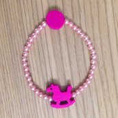 Braccialetto elastico con perline rosa e cavallo a dondolo fatto a mano 