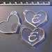 (165) Lotto 3 ciondoli a cuore in plexiglass trasparente con incisione